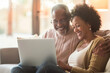© wolfhound911 - Brimming with happiness, a mature couple enjoys a serene moment together at home, each using their laptop, reflecting their shared joy, connection to technology, and loving partnership in retirement.