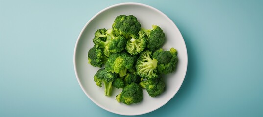 Wall Mural - A top-down view photograph displaying steamed broccoli served on a white plate, with a clear background, allowing the food to stand out, ideal for food photography enthusiasts.