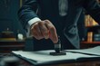 © Zoraiz - a business man pressing the stamp on the paperwork