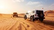 © vetrana - White jeep wrangler driving fast through the sandy desert under the clear blue sky on a sunny day