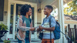 © Alina Tymofieieva - A young African American woman stands with her son on the porch of a house. Happy mother and son talking outdoors on a sunny day. Family concept.