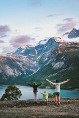 Wall Mural - Family walking outdoor travel summer vacations together in Norway - mother, father and child raised hands enjoying fjord and mountains landscape, hiking adventures active tour in the wild