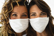 Photo of two women looking straight at camera with face masks during quarantine due to Covid-19 or some other illness.