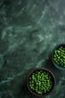 overhead Centered view of a bowl of peas butter on dark green marble kitchen tabletop