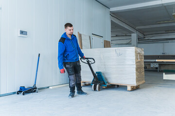 young man pulling a trolley with wooden pieces on it. High quality photo