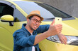 A man take a selfie with his new car showing happy expression