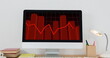 Image of financial data processing with red line over computer screen on desk