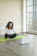 Latin woman teaching yoga online