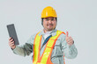 タブレット端末を持って親指を立てる作業服の男性