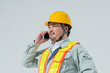 スマートフォンで電話をする作業服の男性