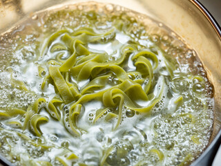 Wall Mural - Spinach pasta boiling in a pot