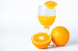Orange juice in a glass and fresh oranges on a white background.