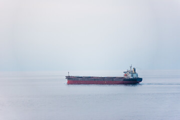 Wall Mural - Cargo ship, bulk carrier sailing through the calm sea.