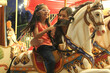 © Arlette - Divorced single mom and 5 year old brunette Latina daughter spend fun time on amusement park carousel
