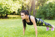 sports girl. young athletic girl stands in plank pose on the grass in nature, sports concept