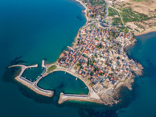 Wall Mural - An aerial view of Side, featuring the charming harbor, Apollo Temple, and ancient Roman ruins in Antalya, Turkey. The scenic coastal town is seen under a clear blue sky.