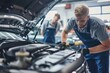 Professional mechanics carefully inspecting and repairing car in modern auto shop