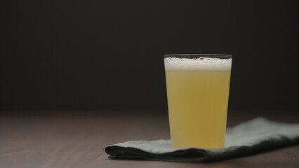 Wall Mural - closeup pour lemonade in a tumbler glass on walnut table