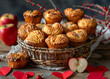 A basket of apple muffins with red heartshaped decorations on the table