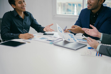 Poster - Three men are sitting at a table with papers and a laptop