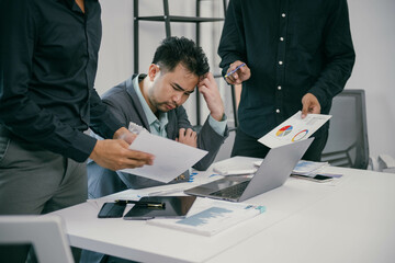 Poster - A man is sitting at a desk with a laptop and papers in front of him