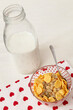 Delicious corn flakes with muesli in a bowl with a bottle of milk. A village background with a beautiful napkin with hearts. Healthy crispy breakfast. The concept of a healthy lifestyle.