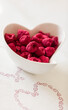 Top view of dried raspberries in a plate in the shape of a heart.