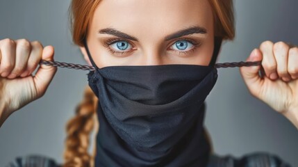Wall Mural -   A woman with blue eyes covers her face with a black cloth