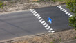 Warning white markings on the edges of an artificial hump or on a speed bump on an asphalt city road in front of a pedestrian crossing. View from above