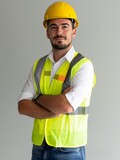 Fototapeta  - Photo of a handsome 30 years old construction worker with yellow helmet and yellow vest clean and new clothes white background atural lighting.