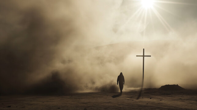 Silhouette of a man in the desert with a cross in the smoke and dust under light the sun, religion concept. 
