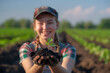young woman holding a plant sprout with soil  in the field