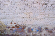 An old brick wall is painted with white paint. Abstract construction background.