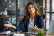 © GustavsMD - Confident Businesswoman Explaining Strategy in Office. Professional businesswoman in a suit discussing and gesturing during a meeting in a contemporary office setting.