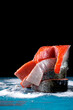 Raw trout steaks on salt against the black background. Fresh seafood ingredient. Cooking red fish. Mockup with copy space