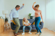 Overjoyed family having fun dancing together in the living room - Sweet grandfather playing with grandchild at home - Happy domestic life style concept