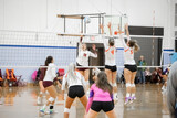 Female college volleyball player rolls the ball over the block