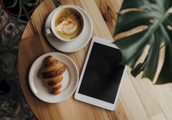 Aufkleber - top view of a white tablet sits on a wooden table next to a croissant and a cup of coffee