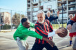 © Davor - Senior men playing basketball in outdoor court