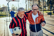 © Davor - Senior friends playing soccer together in urban park