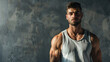 Young bodybuilder man posing on a grey background with negative space text. Gym, workout, exercise, healthy lifestyle, wellness, male, weightlifting.