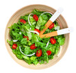 Classic salad of lettuce, tomatoes and onions in a wood bowl with serving utensils isolated on a white background