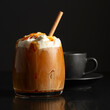 Iced coffee with whipped cream and caramel sauce and cup of black coffee.