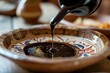 pouring balsamic vinegar into a handcrafted dish
