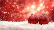   Two red Christmas balls sit atop a mound of white, fluffy snow In front, a red and white brick building of lights shines brightly