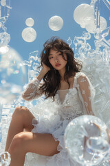 Wall Mural - The beautiful girl is wearing white and silver. She sits in an ice sculpture throne made of crystal balls, adorned with futuristic elements. The background features a blue sky and pure white space