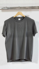 Wall Mural - A charcoal gray blank t-shirt hanging on a hanger made of ash wood, the neutral tones of the shirt 