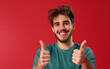 © theevening - Portrait of happy young man showing thumbs up gesture, looking happy, positive, confident and successful.