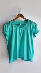 Wall Mural - A bright aqua t-shirt on a vintage-style wooden hanger, illuminated against a white background. 