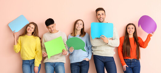 Wall Mural - Group of young people with blank speech bubbles on color background